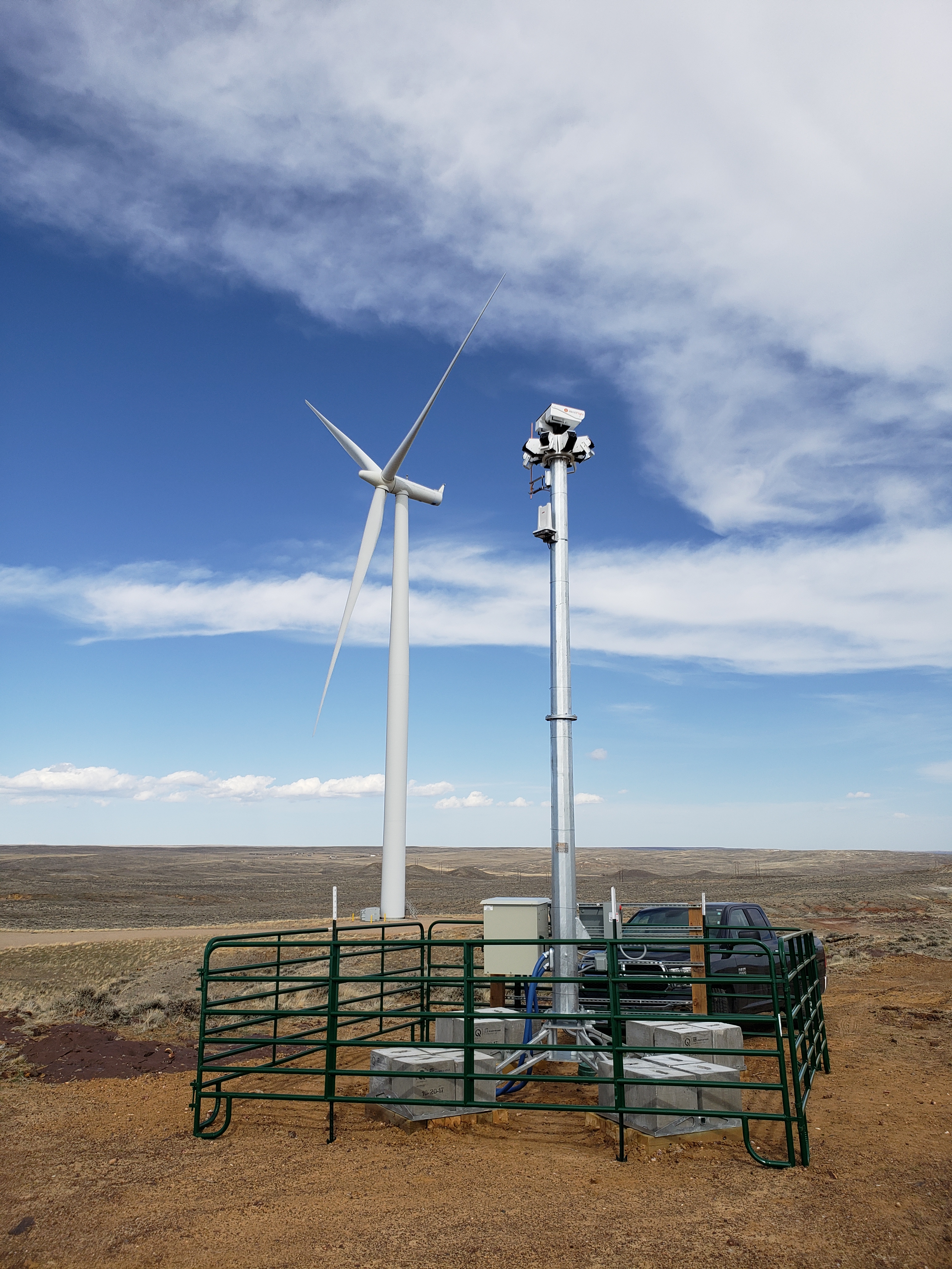 A close up photo of the IdentiFlight automated curtailment system in front of a wind turbine