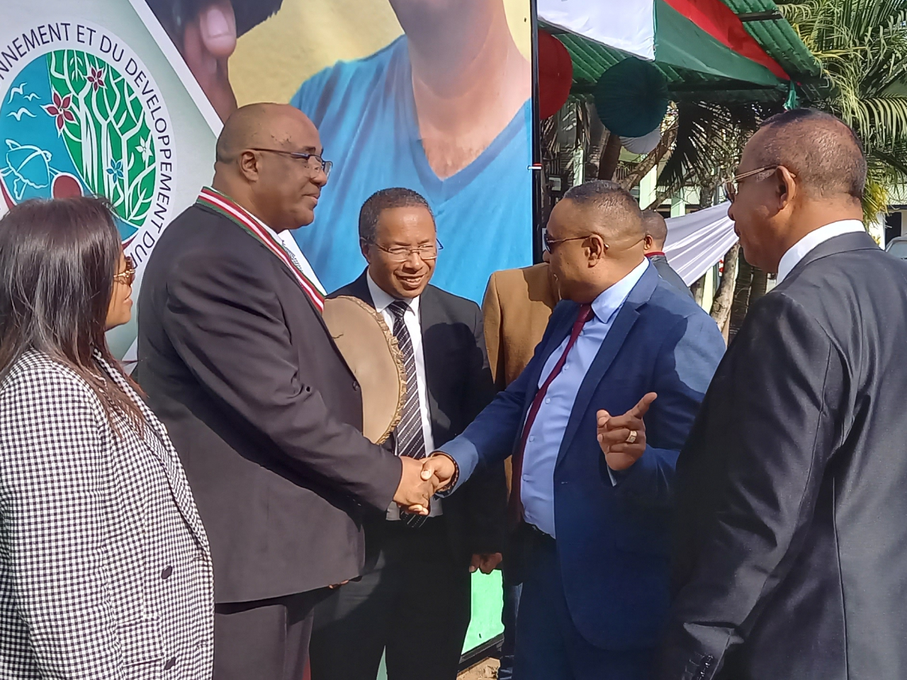 Dr. Lily-Arison René de Roland shakes hands with an attendee at the ceremony where he was awarded the title of “National Order of Madagascar” with the rank of “Commander.”