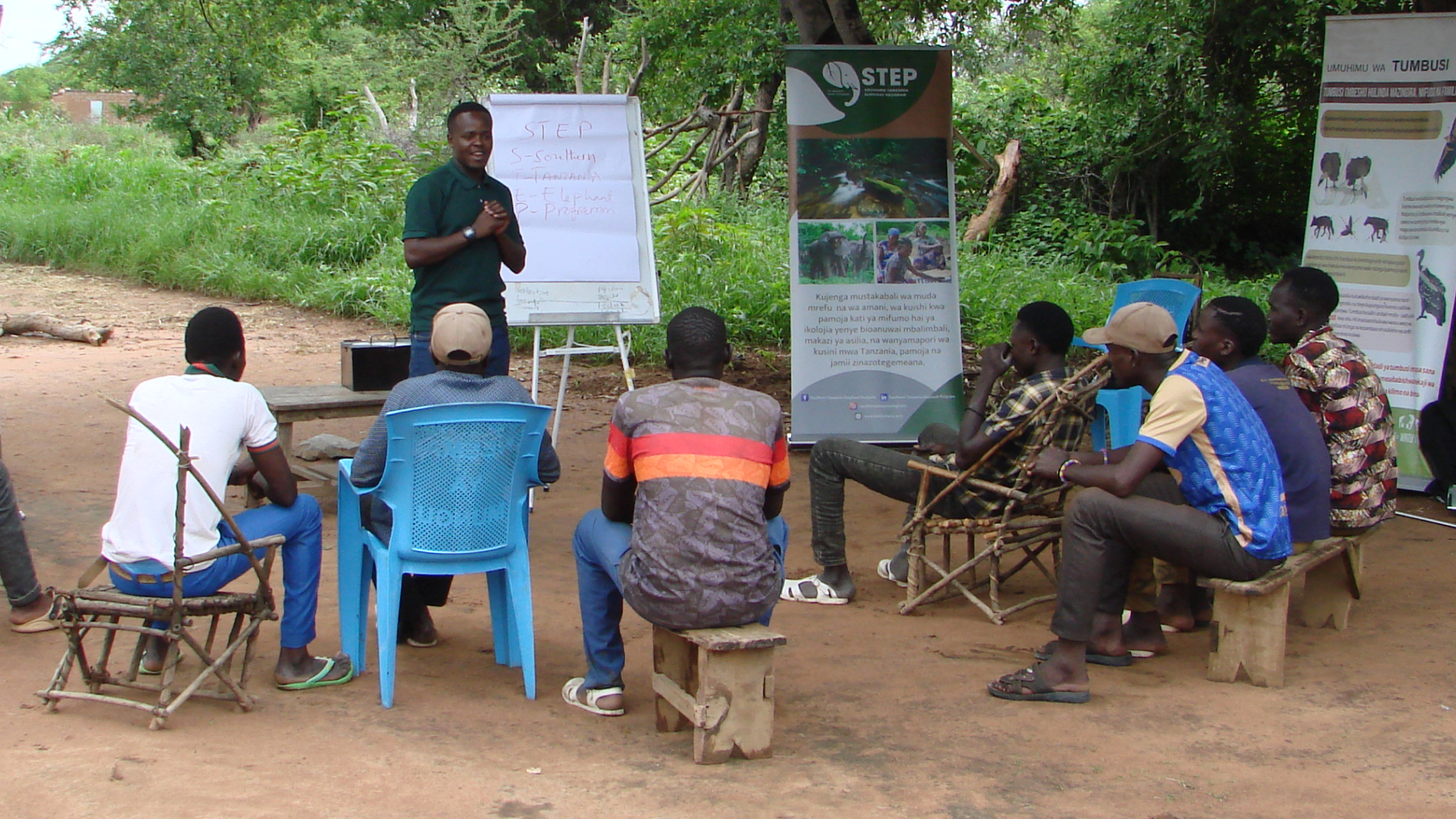 A speaker and gathered community members at an outreach event.