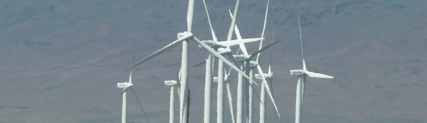 A wind farm in front of distant hills.