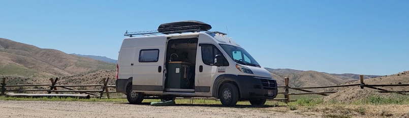 Dan Young's converted camper van parked roadside amongst rolling hills.