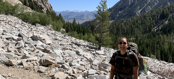 Gabriela Olivares stands on a hiking trail in the mountains