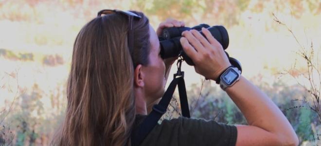 Rachel Felling watching birds with binoculars