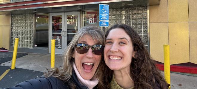 Hannah Single with another person smiling for a selfie in front of the Varsity in Atalanta, Georgia