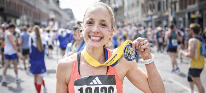 Amanda Morgan posing after a race while holding up a medal around her neck.