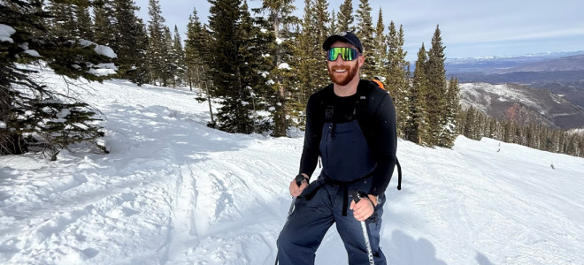 Sam Ditesheim posing for a photo on a snow-covered slope with distant mountains in the background.