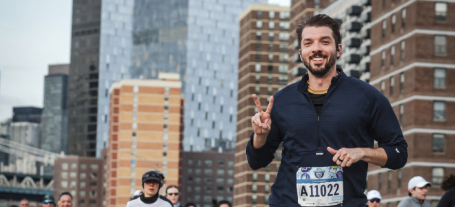 Will Seaton smiling and flashing a peace sign during a race in New York City.