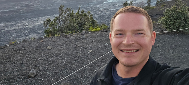 A selfie of Nicholas Sharpe standing in a volcanic field.