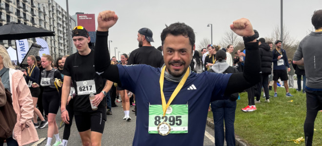 Demian Dalle raising his arms in celebration after completing a race in Copenhagen, Denmark.