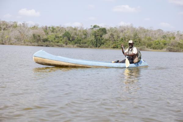 Man in canoe paddling on river