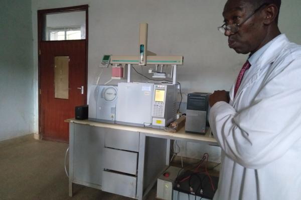 A doctor in a lab coat points to laboratory device during a training demonstration