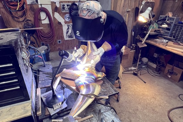 Ross Matteson welding the wings onto the body of the developing Peregrine Falcon statue.