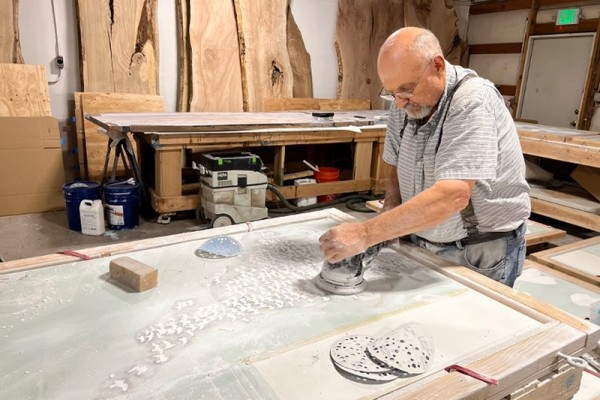 A worker finishing a tile after sandblasted shorebirds have been filled with epoxy.