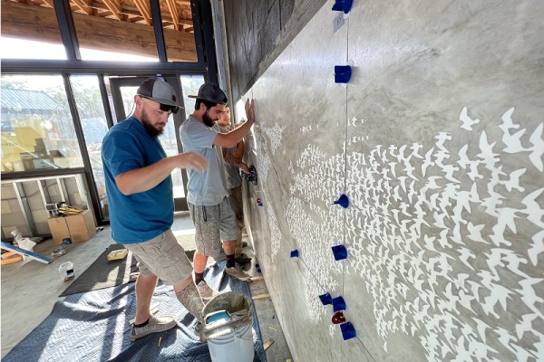 Workers installing the finished stone tiles onsite at the new visitor's center at the World Center for Birds of Prey.