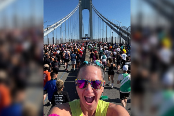 Stacie Johnson, a member of TPF's 2025 TCS NYC Marathon team, takes a selfie surrounded by other runners on the Verrezzano–Narrows Bridge shortly after the start of the race.