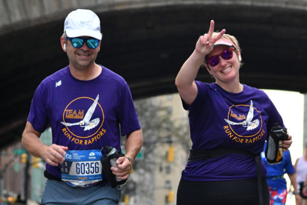 Two members of TPF's 2022 TCS NYC Marathon team smile as they pass the camera during the race.
