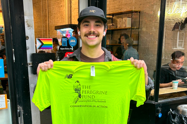Lucas Carmosino, a member of TPF's 2024 TCS NYC Marathon team, poses for a photo holding his TPF team t-shirt.