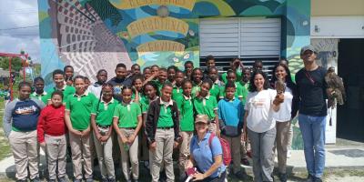 School children in front of a mural together with our staff and avian ambassadors