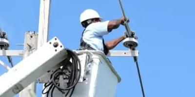 A technician retrofitting power lines