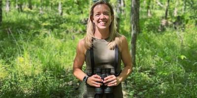 Rachel Felling smiling and holding binoculars