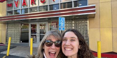 Hannah Single and another person smiling for a selfie in front of the Varsity in Atalanta, Georgia