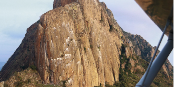 Image of a cliff in the distance photographed from a small plane