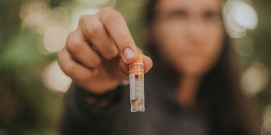 Biologist holding up a tube containing bot fly larvae