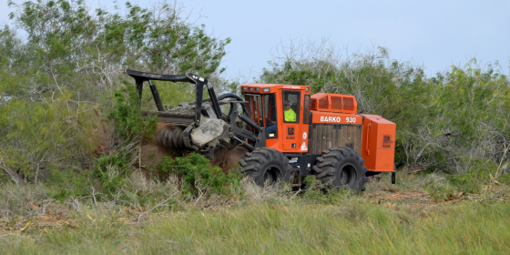 Tractor pushes down woody shrubs