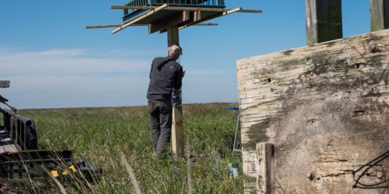 Old wooden nesting structure lays on the ground with new aluminum structure in background