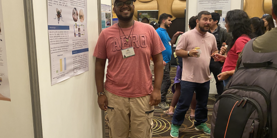 A biologist standing in front of a poster at a conference
