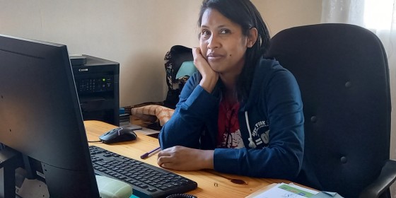 Anjaratiana Rakotondrasoa sitting at a desk and smiling.