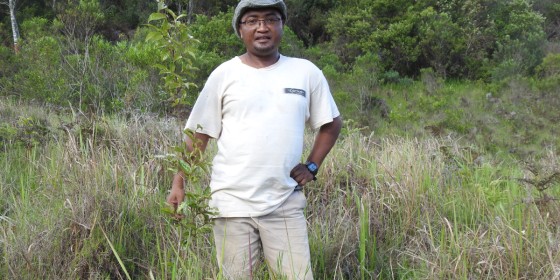 Tolojanahary Andriamalala standing in a grassy field with trees behind him.