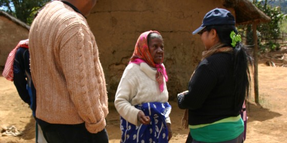 Two members of The Peregrine Fund's Madagascar team speaking to a woman in a Malagasy village.