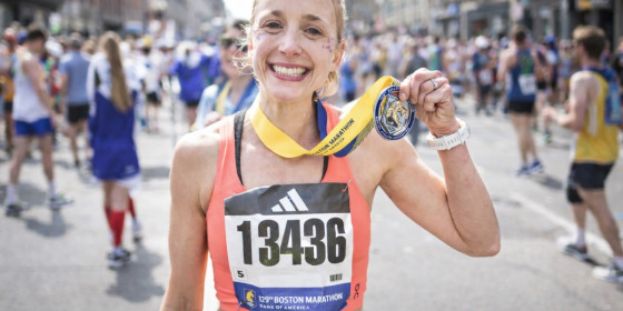 Amanda Morgan posing after a race while holding up a medal around her neck.
