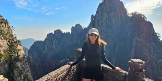 Sara-lee Tuson on an observation deck surrounded by tall rock formations.