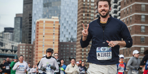 Will Seaton smiling and flashing a peace sign during a race in New York City.