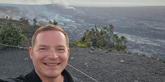 A selfie of Nicholas Sharpe standing in a volcanic field.